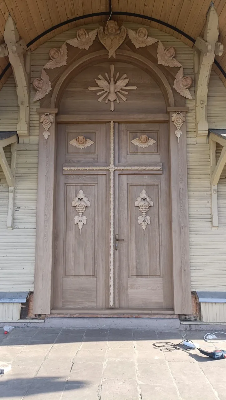 Gerestaureerde houten kerkdeur met snijwerk