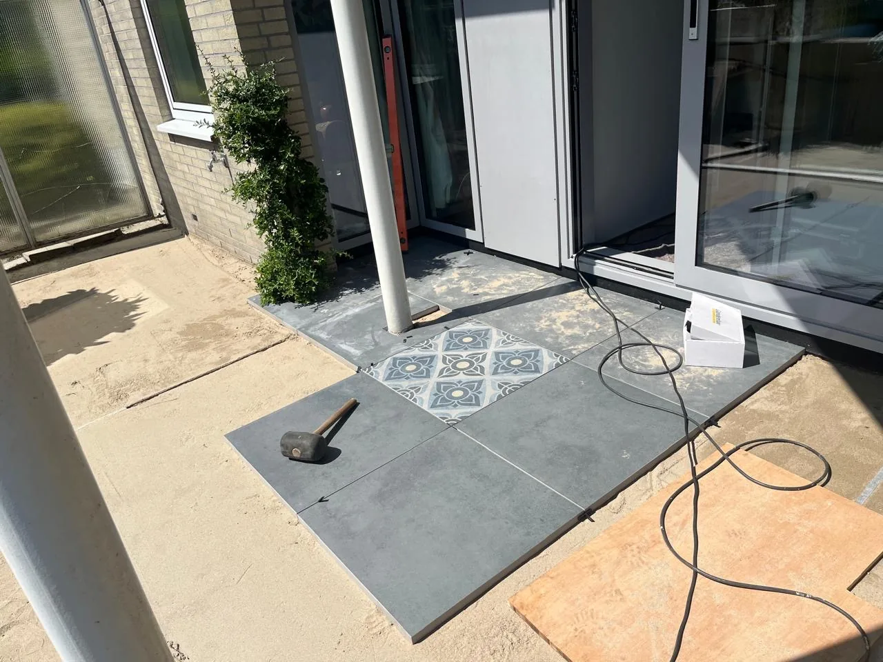 Terrastegels leggen met decoratieve tegel als accent